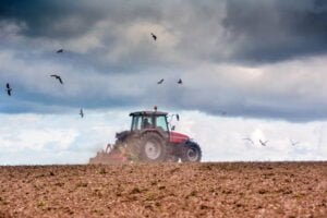 farmer at work in the fields with a disc plough in autumn